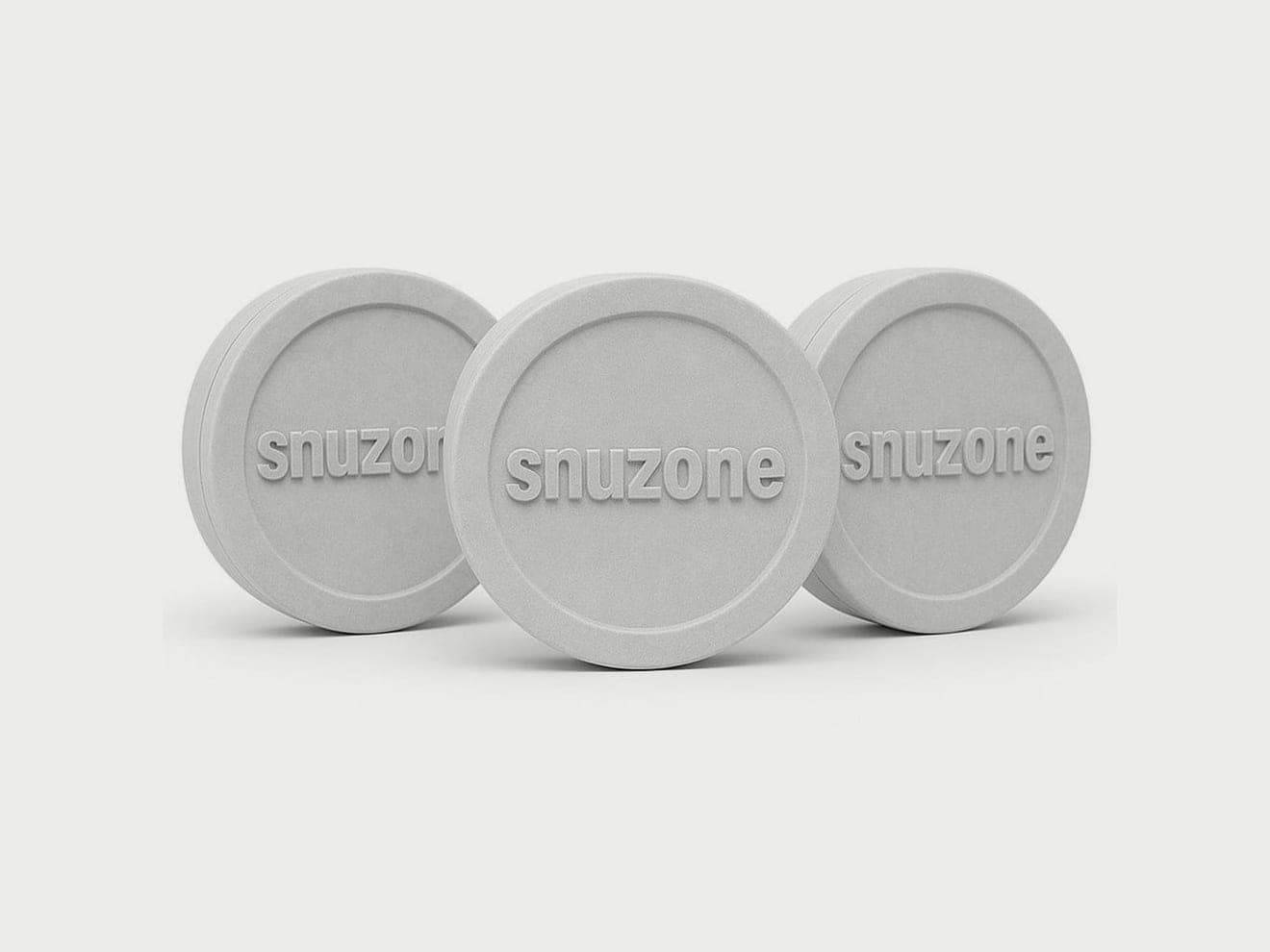 Three round white tins embossed with the Snuzone wordmark, standing on edge on a pale grey ground.