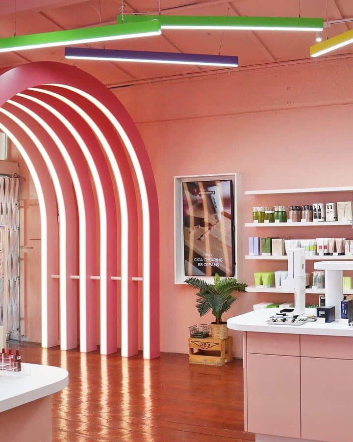 HIKOCO's store: pink walls, white neon arches and shelves of Korean skincare.