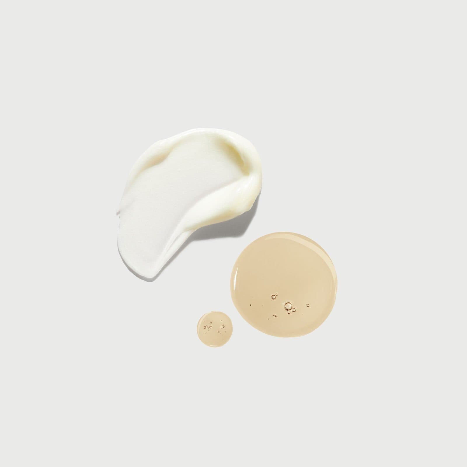 Cream and oil swatches on a bone backdrop.